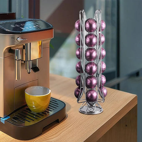 Silver coffee pod holder with purple pods next to yellow cup and espresso machine on wooden counter