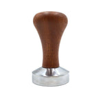 Coffee tamper with smooth wooden handle and stainless steel base on white background