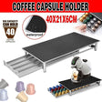 Waterproof black coffee capsule holder with metal drawer storing 40 colorful coffee pods, alongside a coffee machine