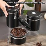 Black airtight coffee storage jars with metal clasps, one open with coffee beans inside