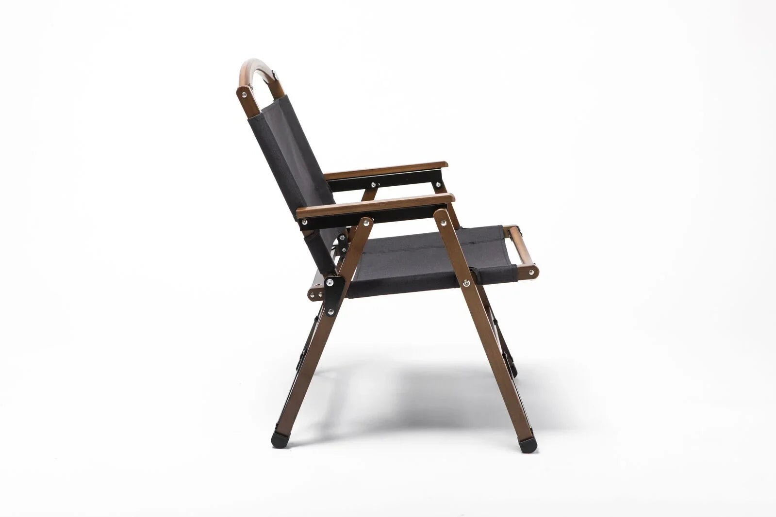 Side view of a black fabric and wooden outdoor folding chair with armrests on white background