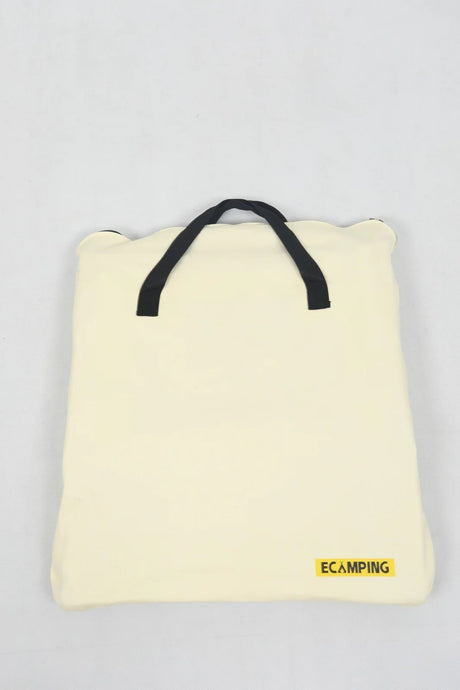 Cream-colored soft square camping cushion with black handles and yellow ECAMPING logo