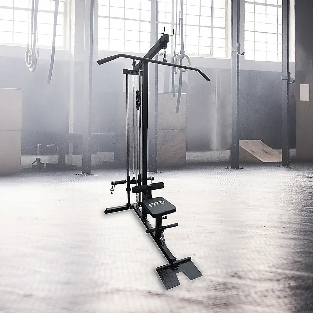 Lat pulldown machine in a gym with large windows and gymnastic rings