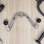 Chrome tricep pushdown attachment with black ball handles on light wood gym floor