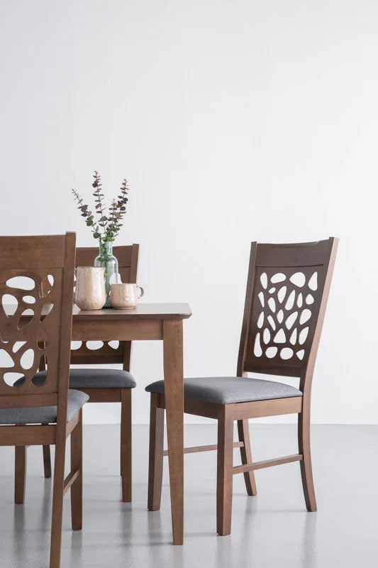 Modern wooden dining set with cut-out back chairs and grey cushions in minimalist room