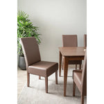 Brown leather dining chairs and wood table in modern dining room with potted plant