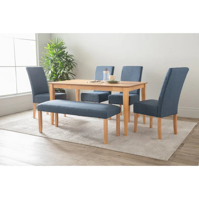 Modern dining table set with blue upholstered chairs and bench on a light rug