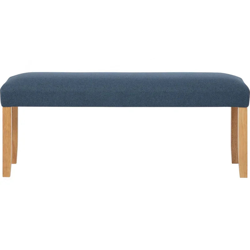 Modern upholstered bench with blue cushion and wooden legs on white background