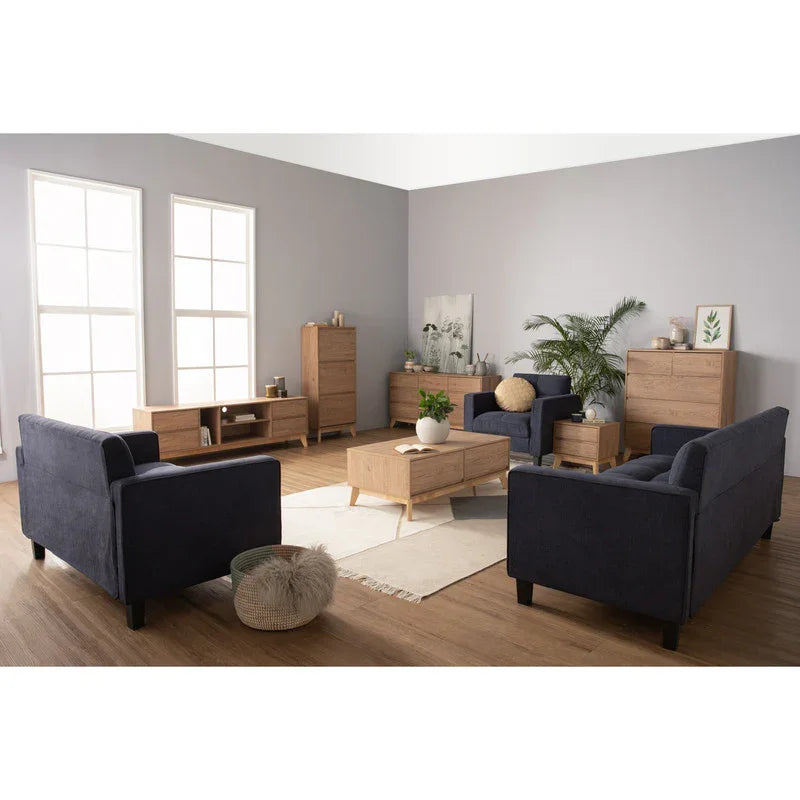 Modern living room with navy sofas, light wood furniture, and indoor plants