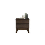 Mid-century modern dark wood nightstand with two drawers, candles, and decorative book on top
