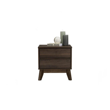 Mid-century modern dark wood nightstand with two drawers, candles, and decorative book on top