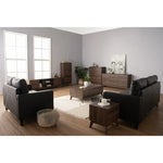 Modern living room with black sofas, walnut wood furniture, and gray walls