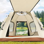 Interior view of a spacious beige camping tent with mesh windows set up on green grass by a lake and forest