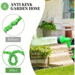 Hand holding green anti kink garden hose spray nozzle watering outdoor plants near house steps