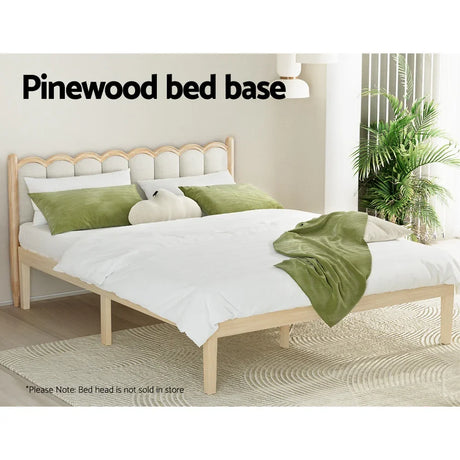 Pinewood bed base with white bedding and green pillows in a bright, modern bedroom