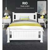 Modern white wooden bed with gray and yellow bedding in a stylish bedroom with nightstands and lamps