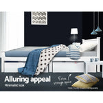 White minimalist bed with blue striped bedding, polka dot blanket, under-bed storage drawers