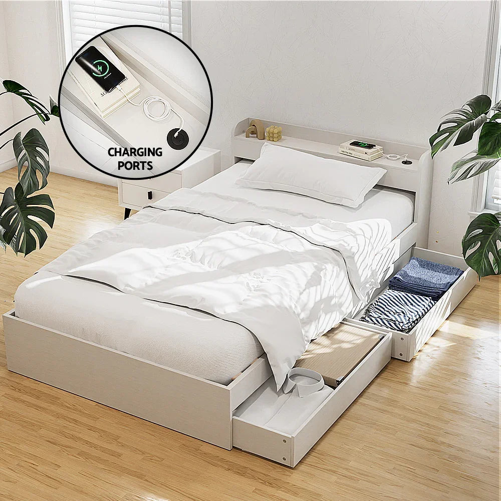 White platform bed with under-bed storage drawers and built-in charging ports in a bright bedroom