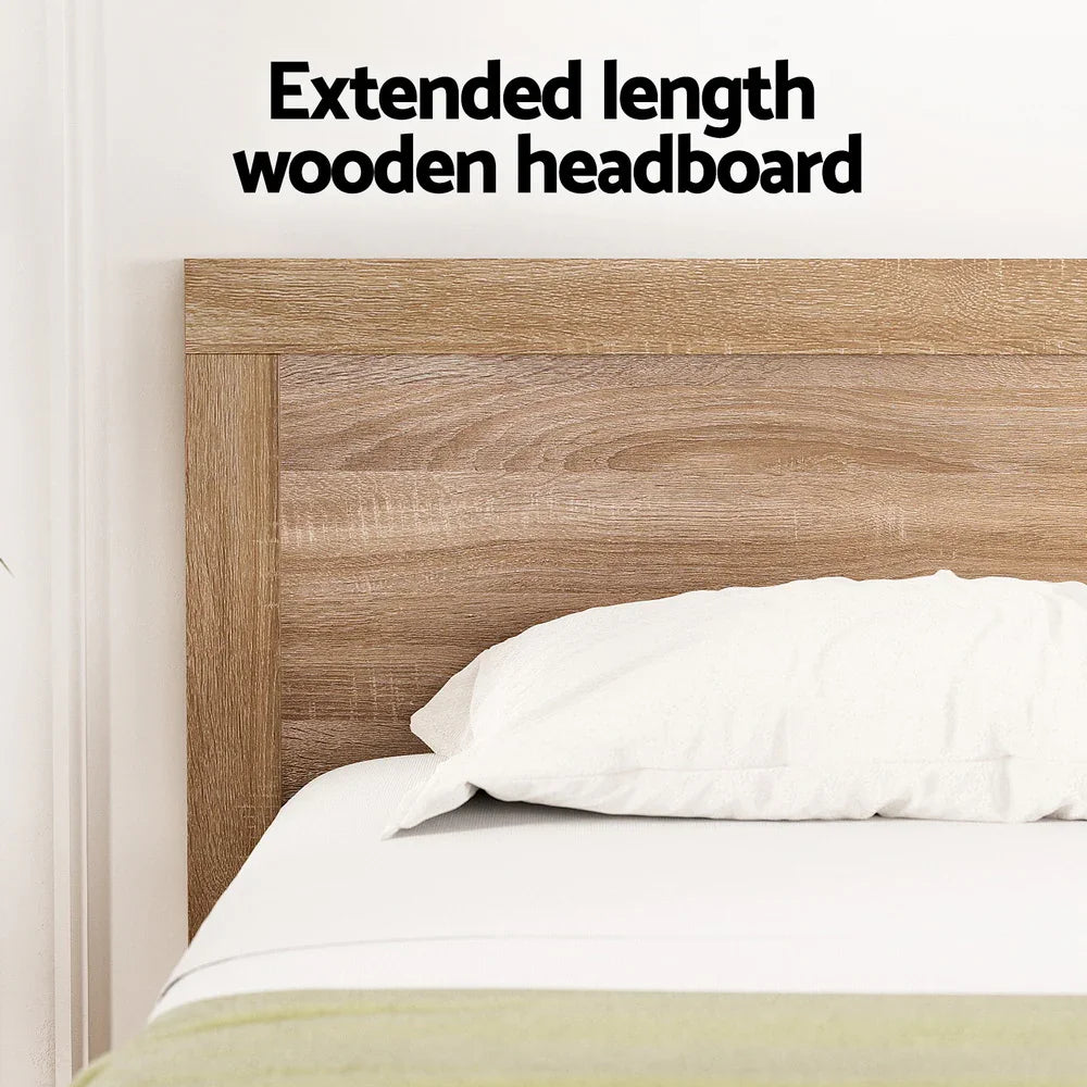Extended length wooden headboard in oatmeal color with white pillow on bed