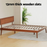Wooden bed frame with 13mm thick slats, mid-century modern style, in bright room with plant